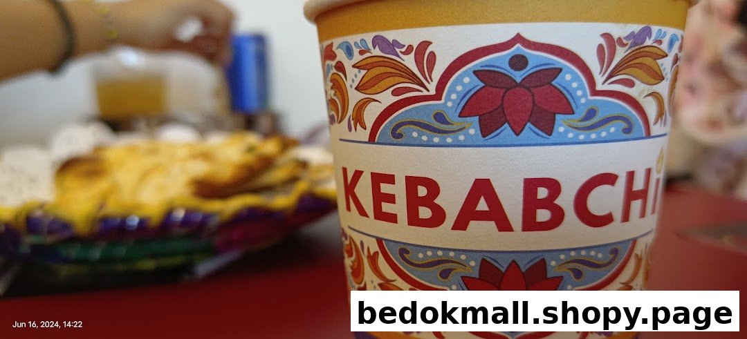 Close-up of a Kebabchi branded cup with food in the background.