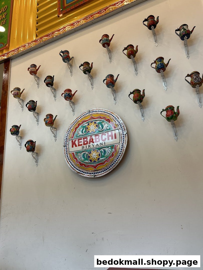 Interior wall decorated with small teapots and a Kebabchi Biryani sign.