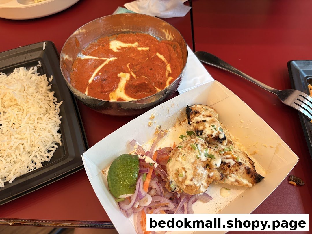 Table setting with Indian food: rice, curry, and grilled chicken.