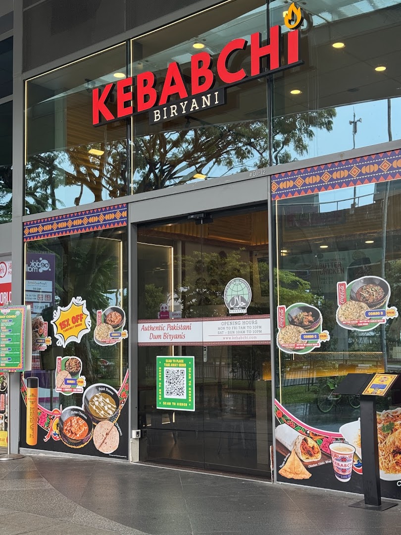 Exterior view of Kebabchi Biryani shop with signage and promotional materials.
