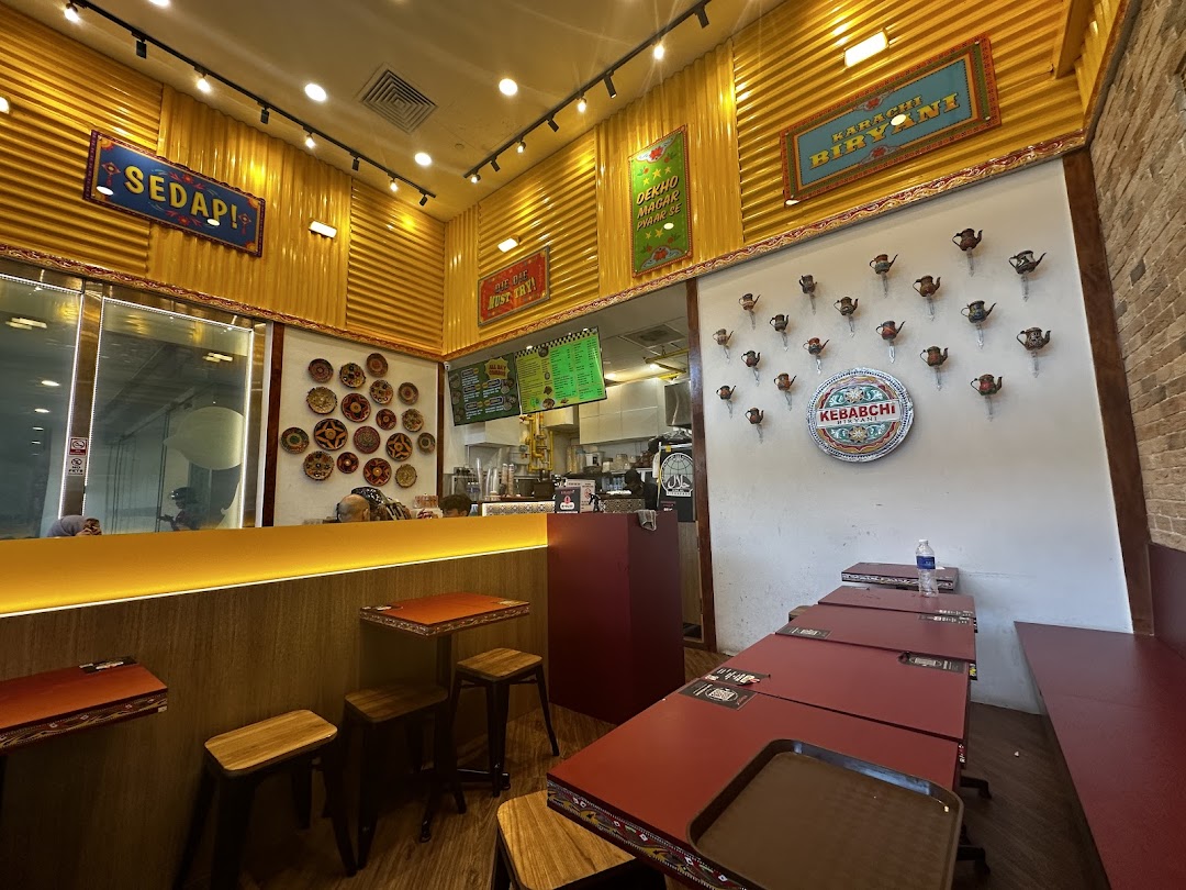 Interior view of a Kebabchi Biryani restaurant with tables, counter, and wall decor.