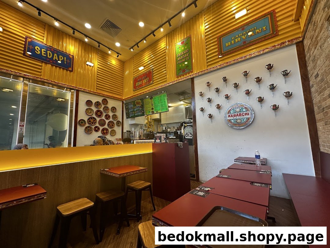 Interior view of a Kebabchi Biryani restaurant with tables, counter, and wall decor.