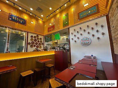 Interior view of a restaurant with dining tables, a service counter, and wall decor.