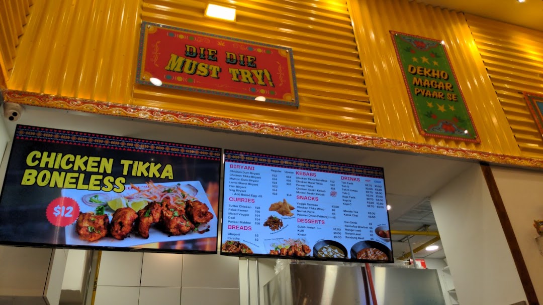 Digital menu boards displaying various food items and prices inside a shop.