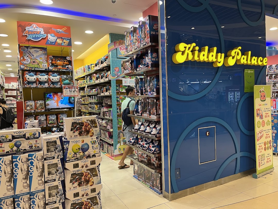 Interior view of a Kiddy Palace toy store with shelves of products and a customer.