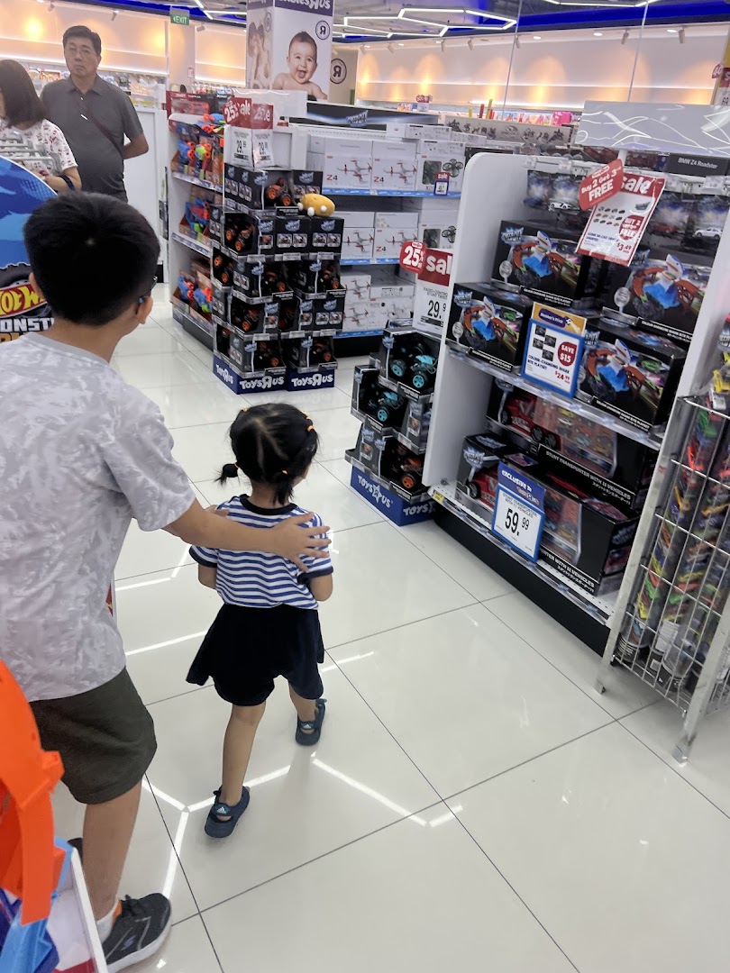 People browsing toys on shelves in a brightly lit store.