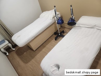 Two treatment beds with heat lamps in a clinic room.
