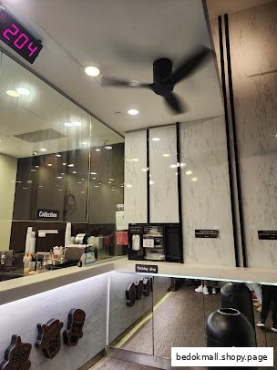 Interior view of a shop counter with a collection area and ceiling fan.