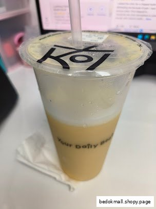 A close-up of a KOI bubble tea drink in a plastic cup with a straw.