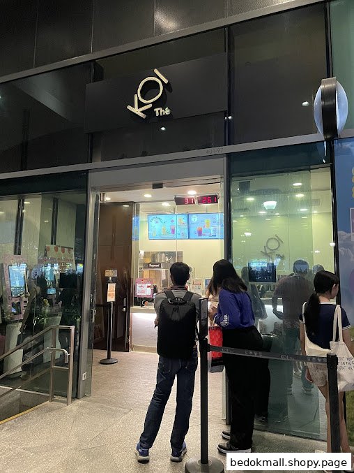 Exterior view of Koi Thé shop with people waiting outside.