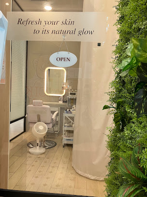 Interior view of a facial treatment room with chair, mirror, and products.