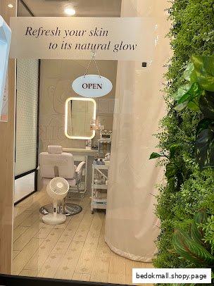 Interior view of a facial treatment room with chair, mirror, and products.