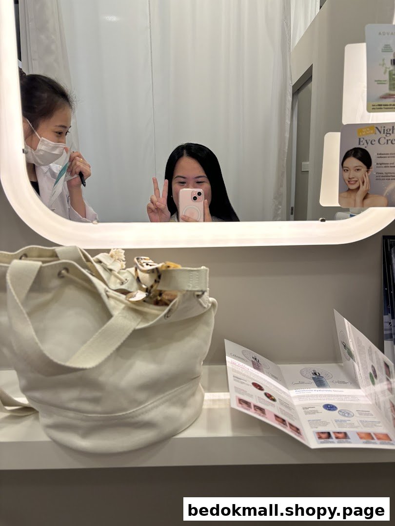 Reflections of two people in a mirror with a bag and brochures on a shelf.