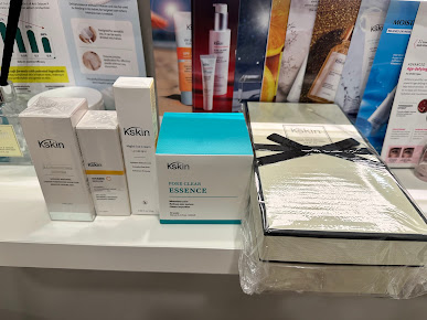Skincare products displayed on a shelf with promotional materials in the background.