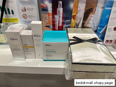 Skincare products displayed on a shelf with promotional materials in the background.