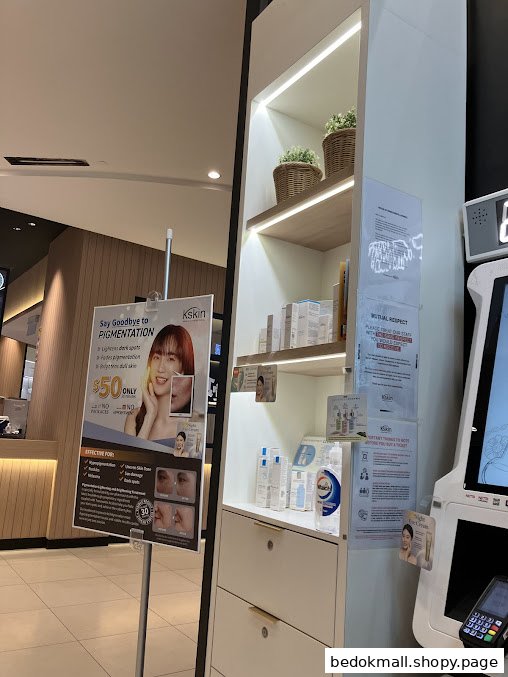 Interior view of a Kskin shop with product display, promotional poster, and kiosk.