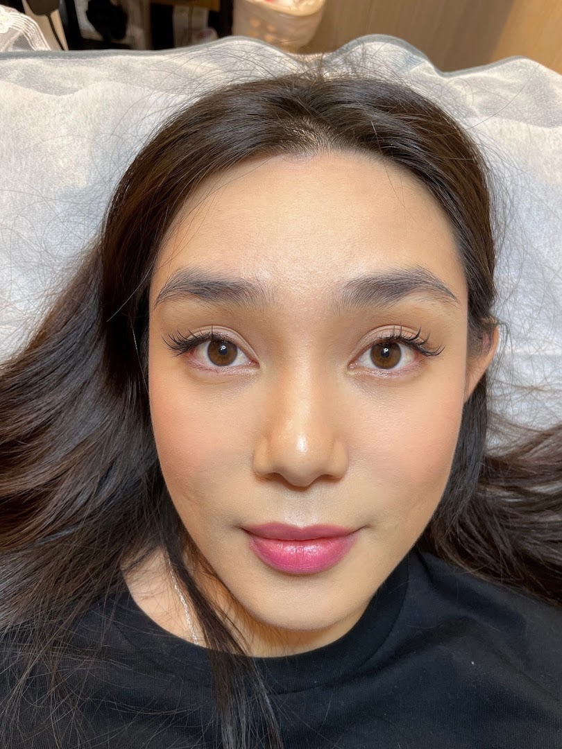 Close-up of a woman's face with enhanced eyelashes and makeup.