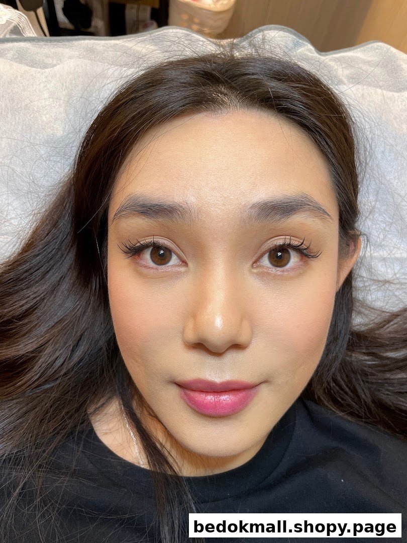 Close-up of a woman's face with enhanced eyelashes and makeup.