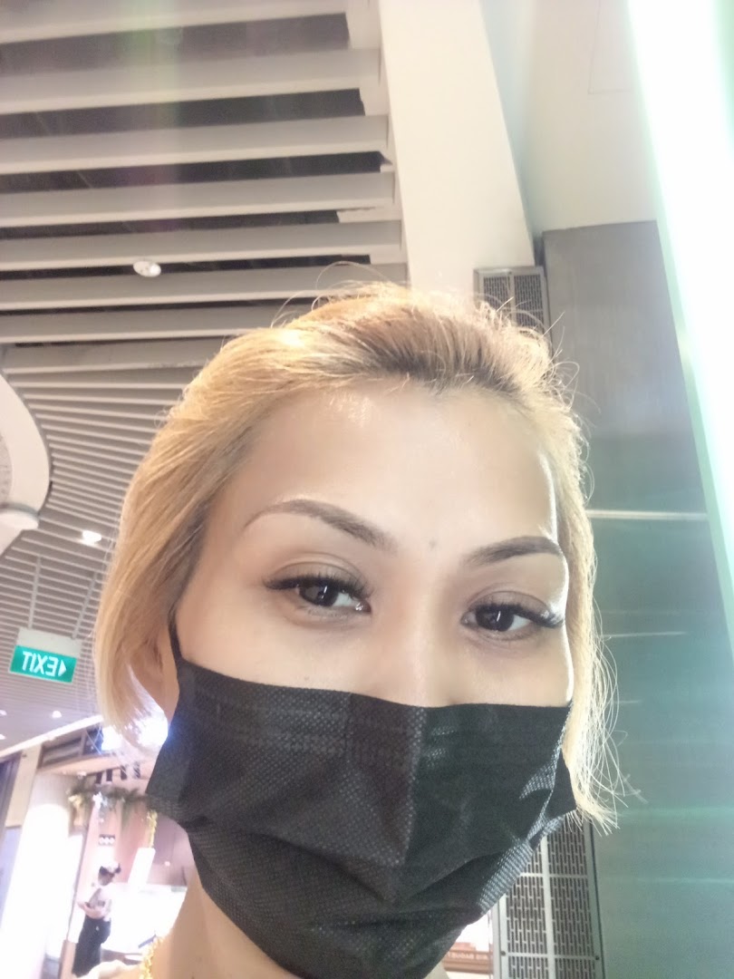 Close-up of a person wearing a black face mask indoors.