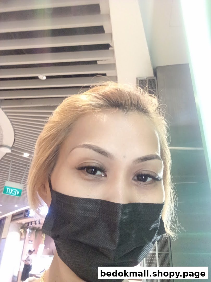 Close-up of a person wearing a black face mask indoors.