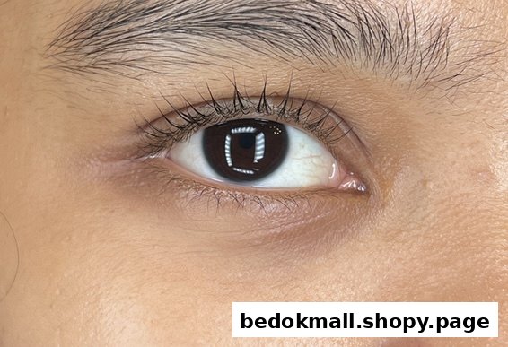 A close-up of a human eye with enhanced eyelashes, likely after a beauty treatment.