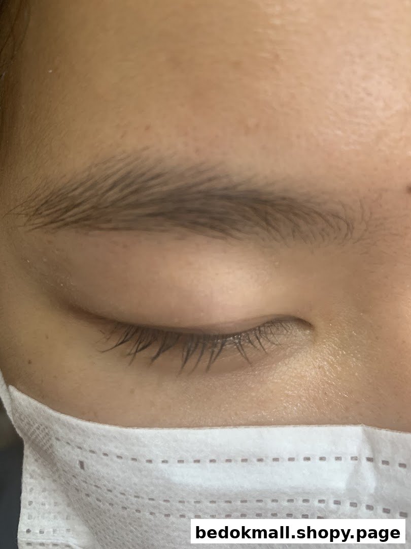 Close-up of a person's eye, eyebrow, and face mask.