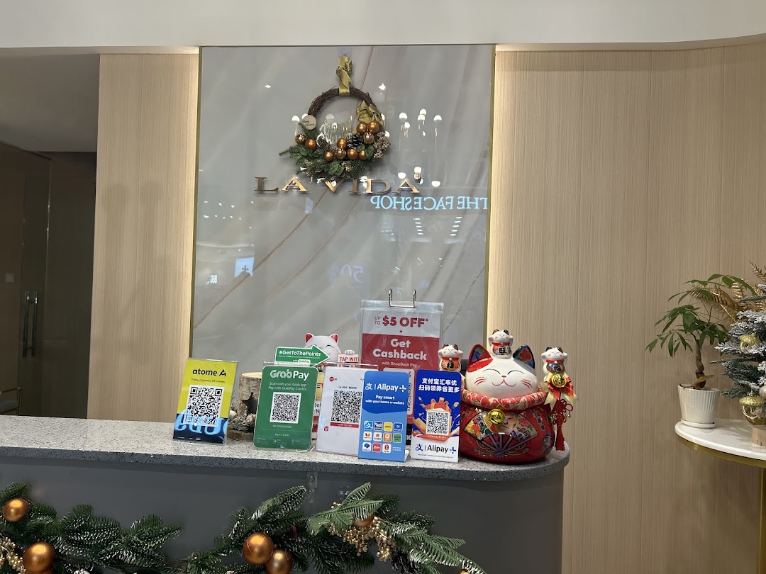 Shop counter with payment QR codes, promotional signs, and festive decorations.