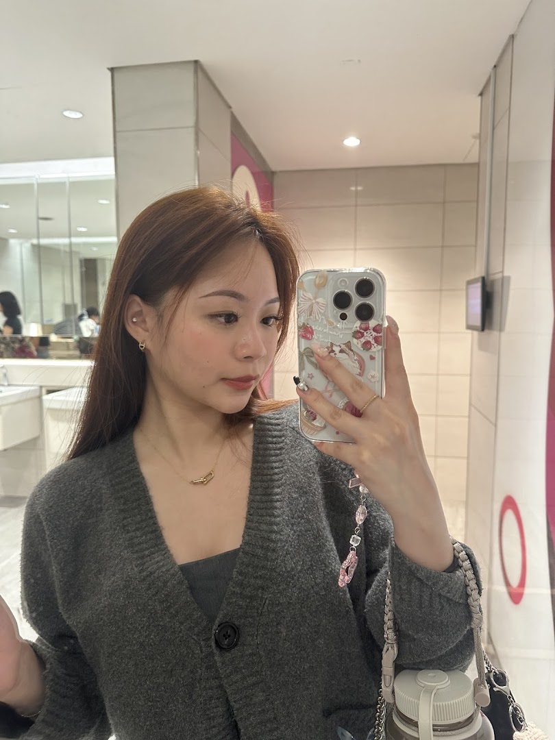 Woman taking mirror selfie with phone.