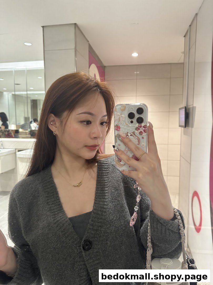 Woman taking mirror selfie with phone.