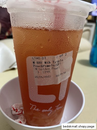 A close-up of a cold beverage in a plastic cup with a product label.