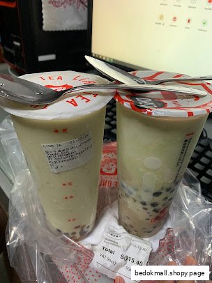 Two bubble tea drinks with a receipt on a table.