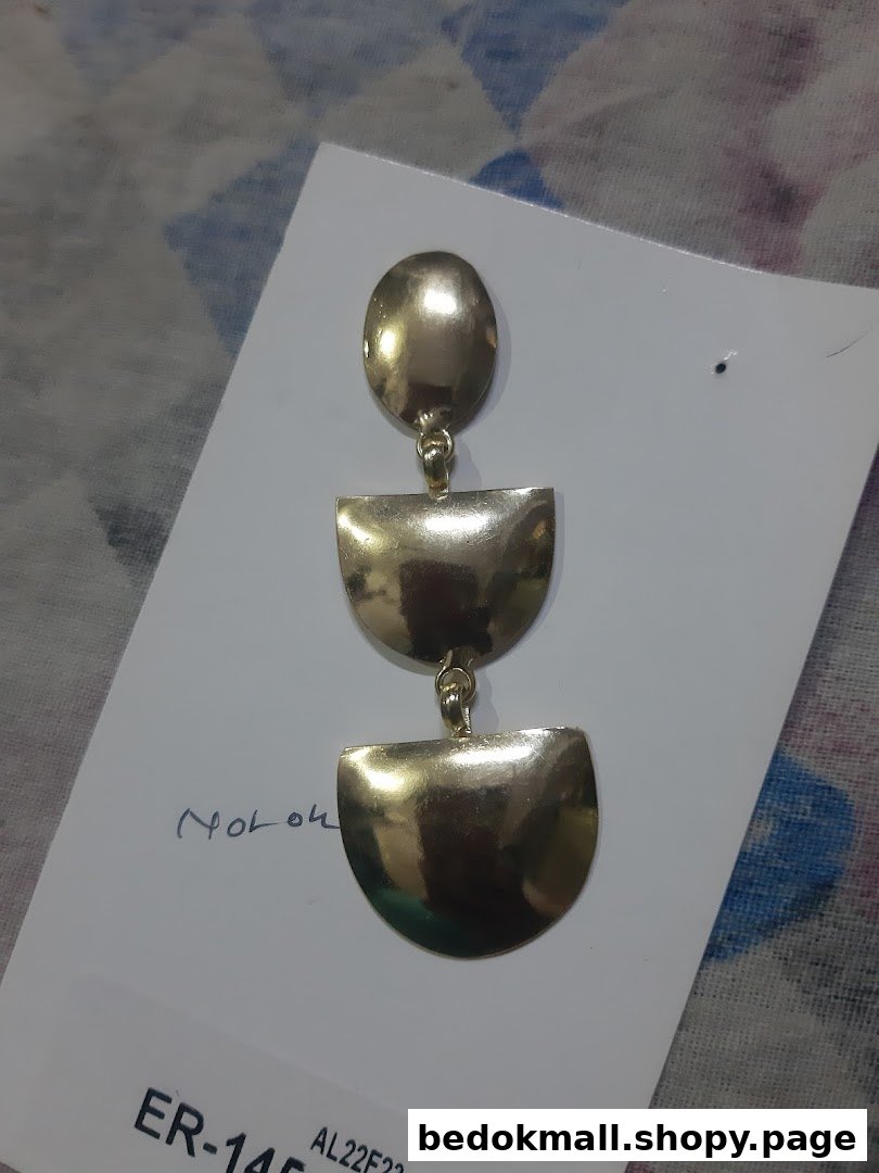 A gold-colored dangle earring on a white product card.