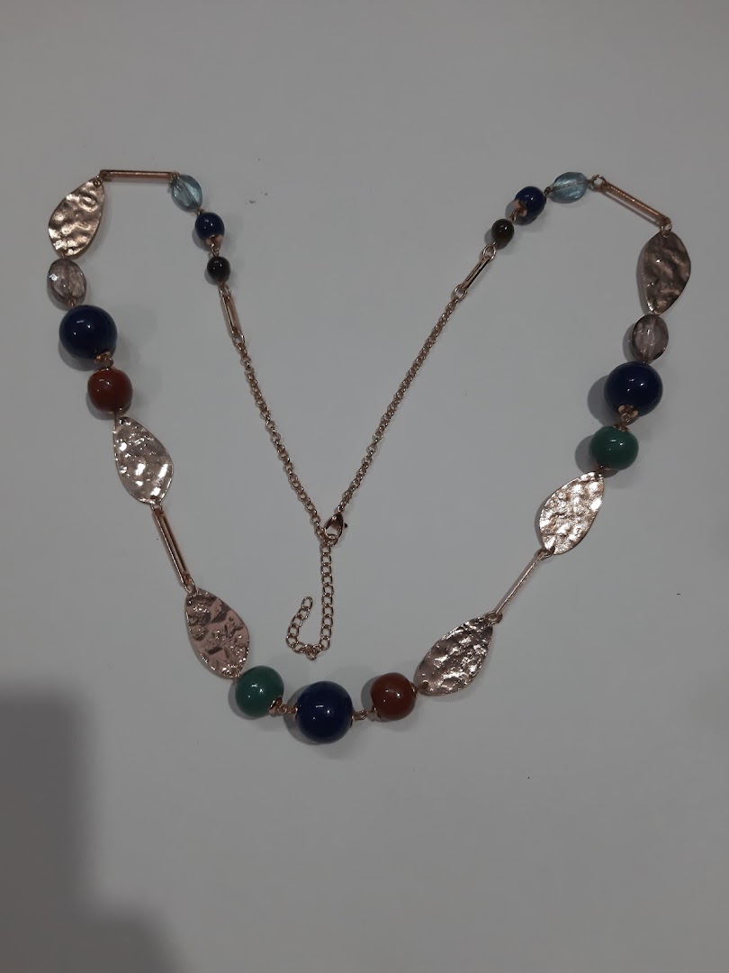 A long necklace with colorful beads and hammered metal leaf accents.