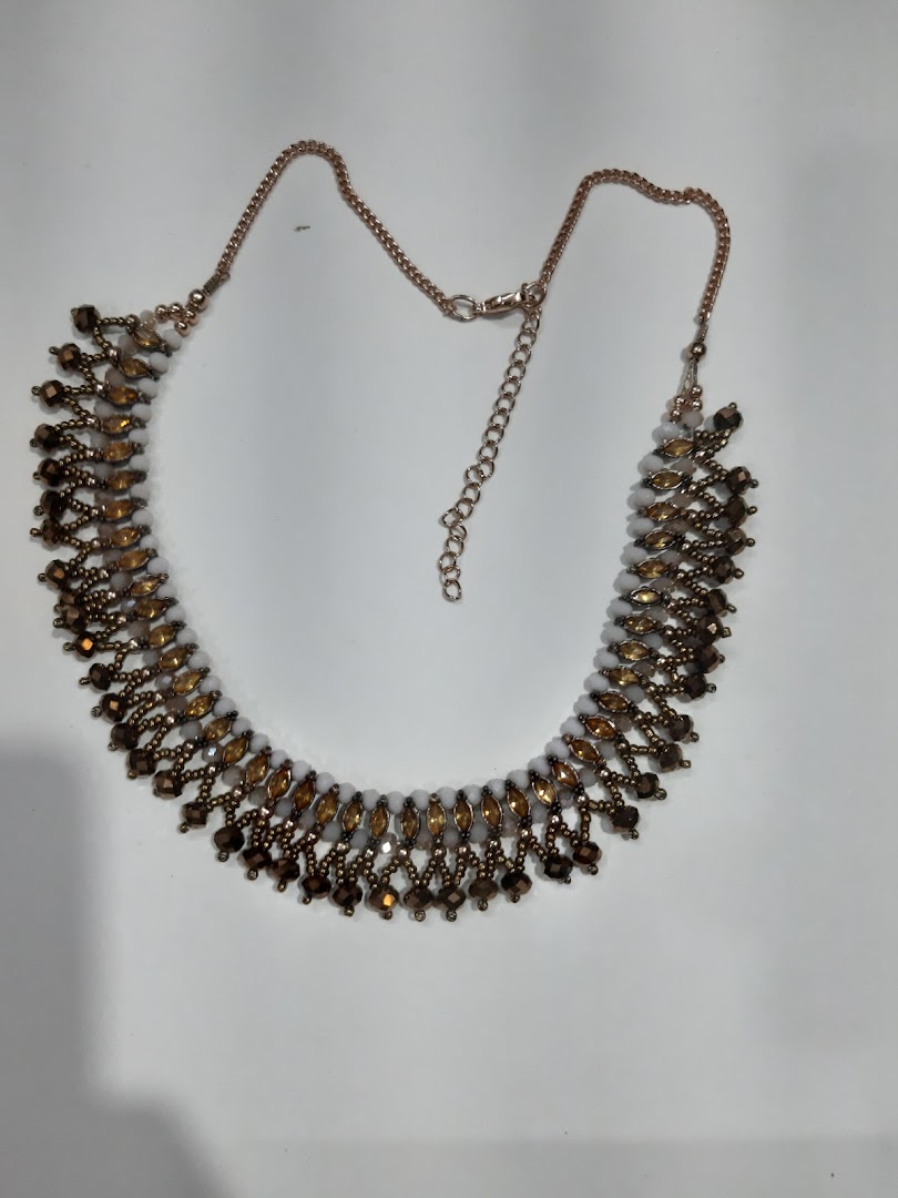 Beaded necklace with chain on a white background.
