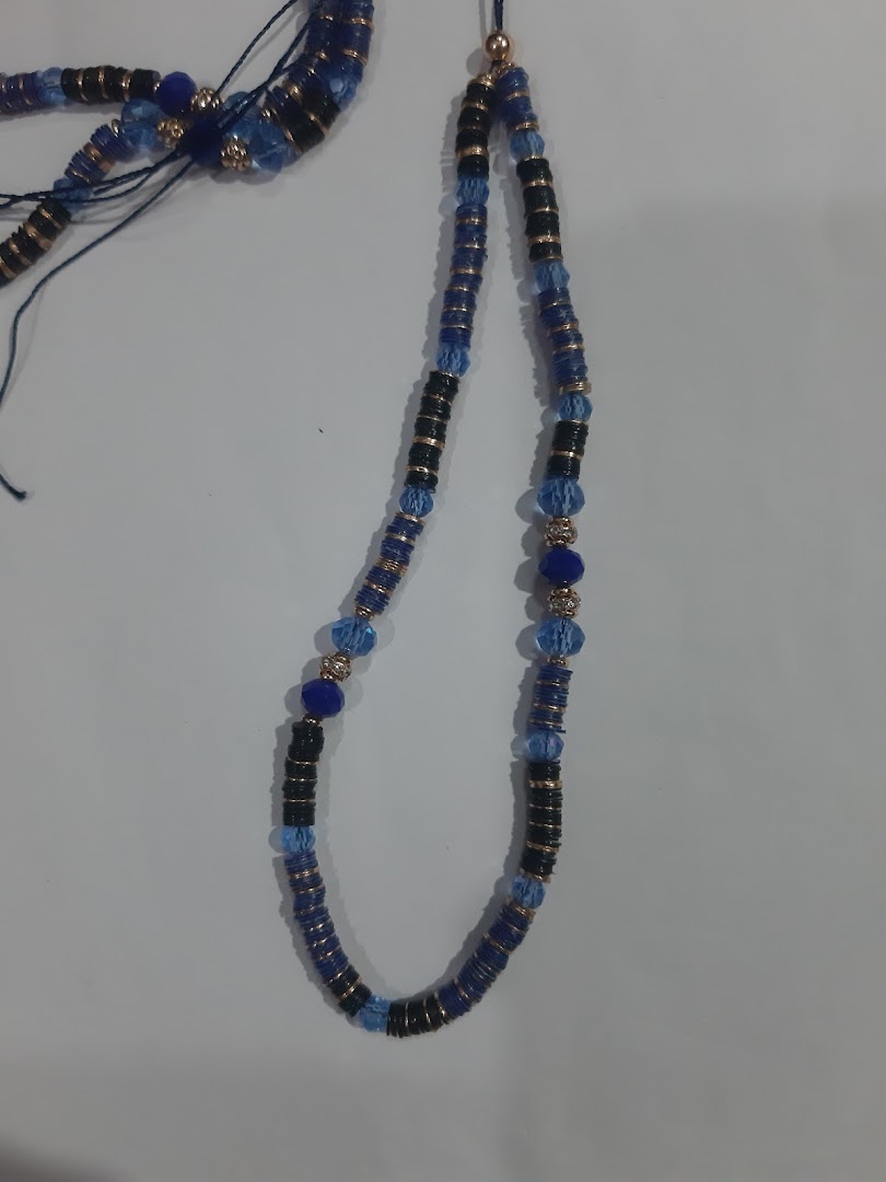Blue and black beaded necklace with gold accents on a light background.