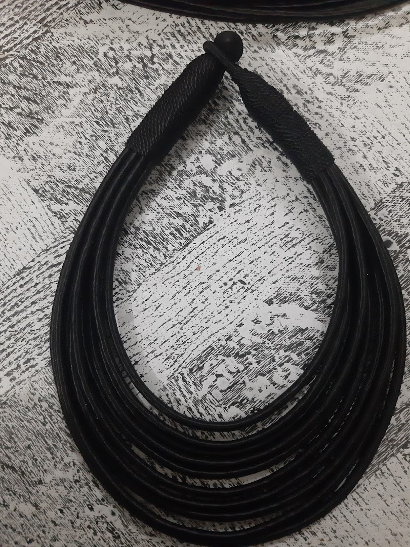 A black multi-strand necklace on a textured surface.