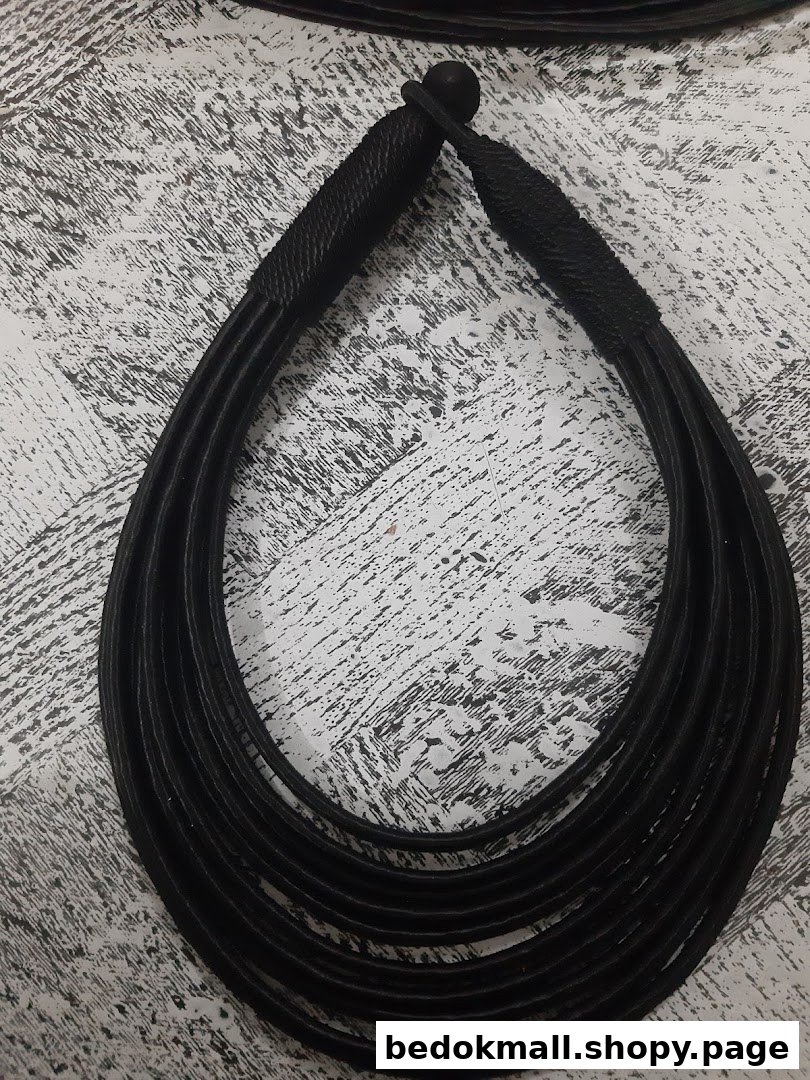 A black multi-strand necklace on a textured surface.
