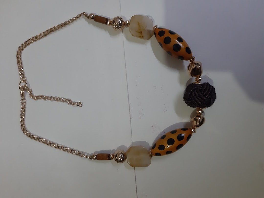 A close-up of a necklace with spotted, solid, and knotted beads.