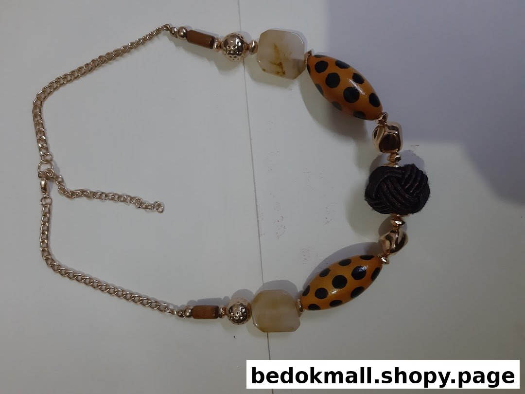 A close-up of a necklace with spotted, solid, and knotted beads.