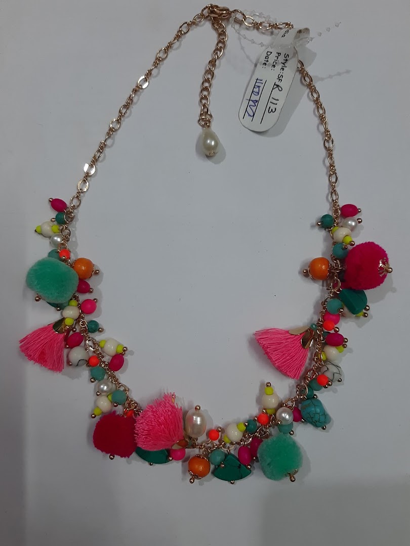 Colorful necklace with beads, tassels, and pom-poms on a white background.
