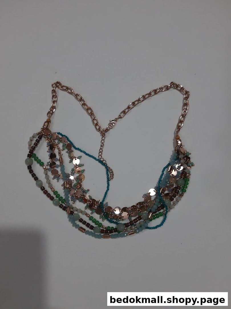 A multi-strand necklace with beads and metallic discs on a light background.