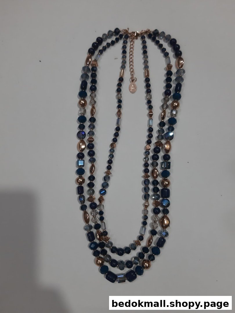 Multi-strand beaded necklace with blue and gold beads on a white background.