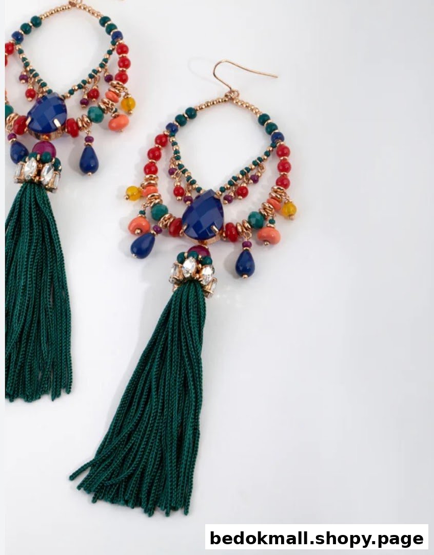 A pair of colorful, beaded earrings with green tassels on a white background.