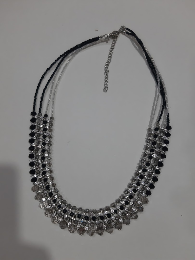 A black and clear beaded necklace on a white background.
