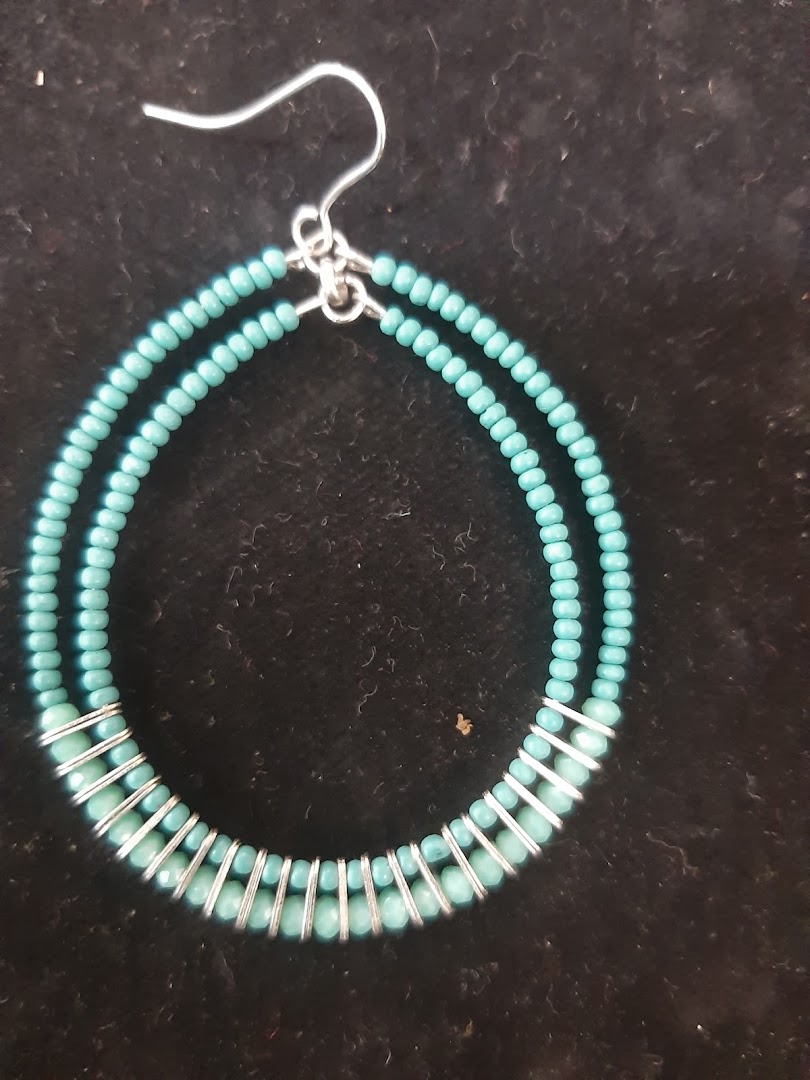 Close-up of a turquoise beaded hoop earring with silver wire.