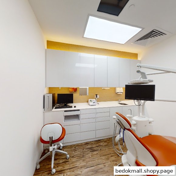Interior view of a dental clinic room with a chair and equipment.