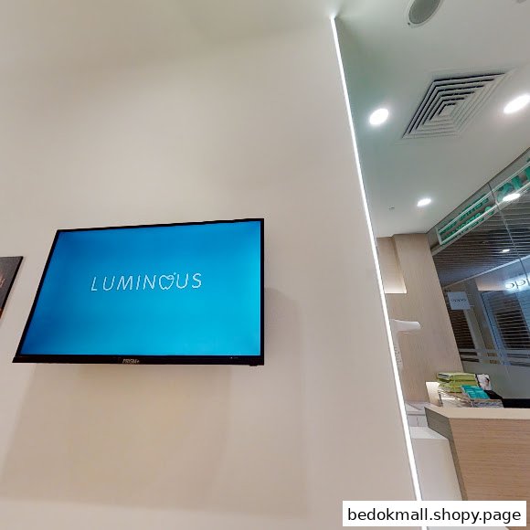 Interior view of a reception area with a TV displaying the clinic name.