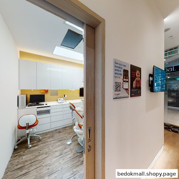 Interior view of a modern dental clinic room with a dental chair and equipment.