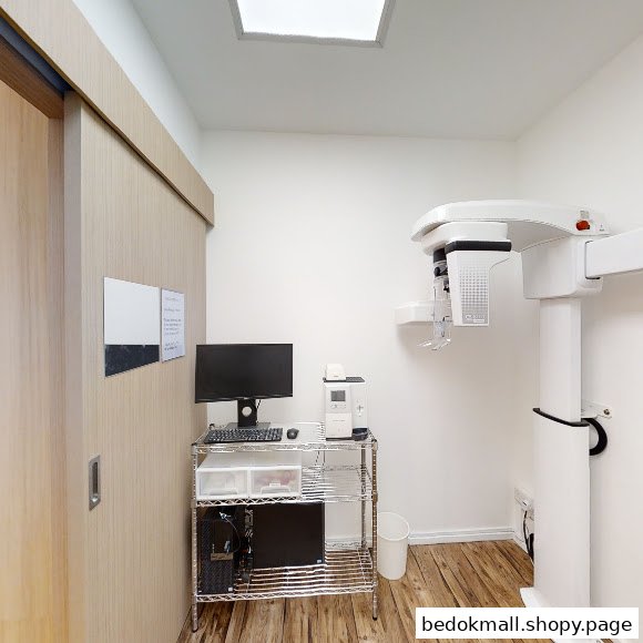 Interior room with dental imaging equipment and computer workstation.