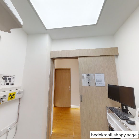 Interior view of a dental clinic room with a sliding door and computer.